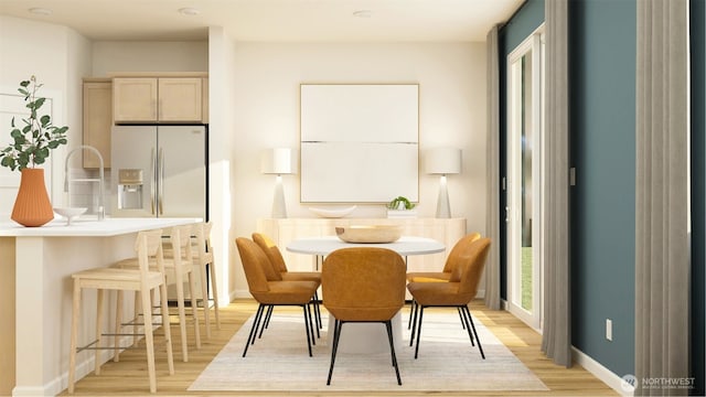 dining room with baseboards and light wood finished floors