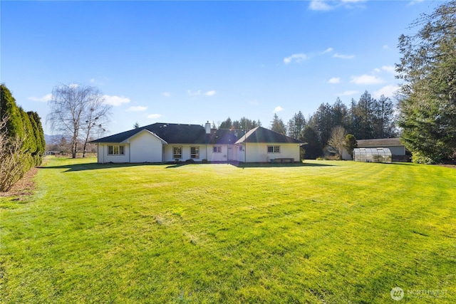 rear view of property featuring a yard