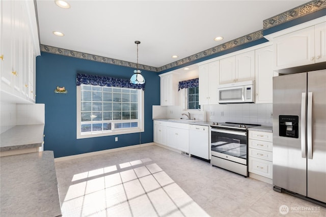 kitchen featuring white cabinets, stainless steel appliances, and a sink