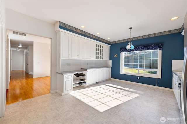 kitchen featuring glass insert cabinets, baseboards, visible vents, and white cabinets