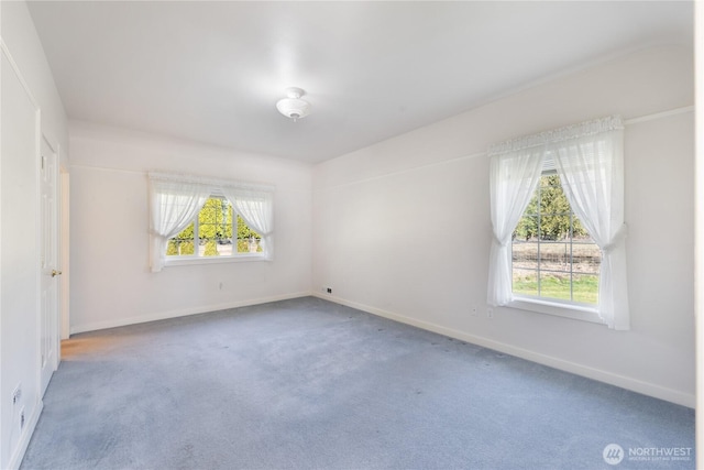 carpeted spare room featuring baseboards