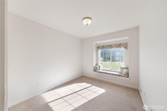 carpeted empty room featuring baseboards