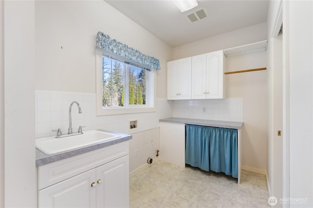 clothes washing area featuring washer hookup, cabinet space, a sink, and visible vents