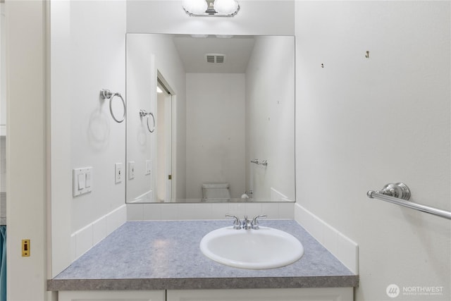 bathroom featuring toilet, visible vents, and vanity