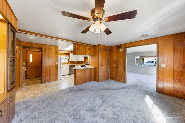 kitchen with light carpet, stainless steel appliances, light countertops, and brown cabinets