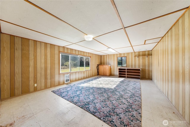 interior space featuring heating unit, wood walls, and tile patterned floors