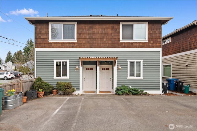 view of front of home with uncovered parking and fence