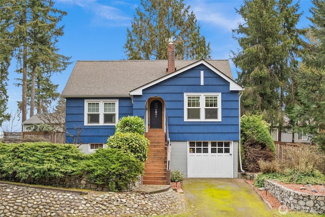 view of front facade featuring driveway, a garage, a chimney, and fence