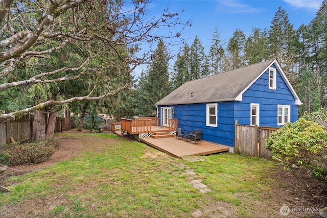 rear view of property with french doors, roof with shingles, a lawn, a fenced backyard, and a wooden deck