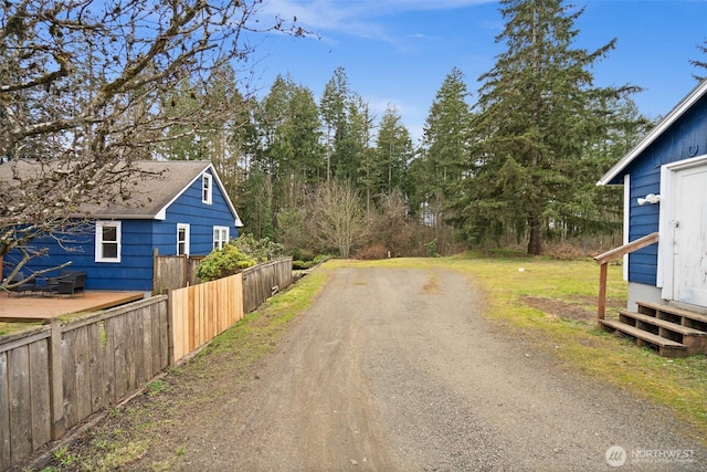 view of road featuring dirt driveway and entry steps