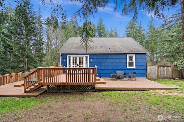 back of property featuring a deck, french doors, roof with shingles, and fence