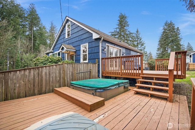 deck featuring a covered hot tub and fence