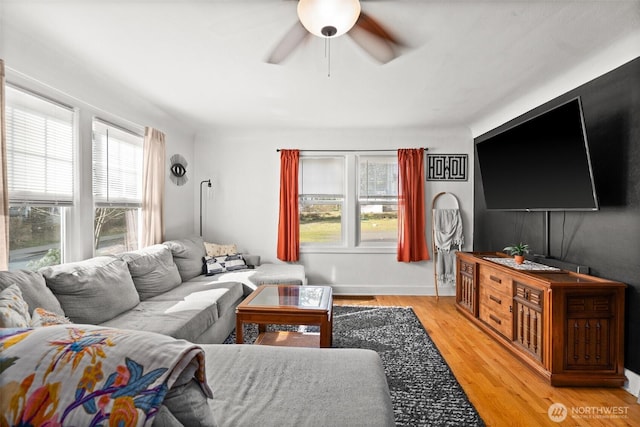 living area featuring a ceiling fan and wood finished floors