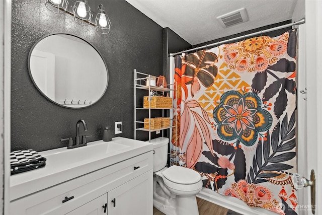 bathroom featuring visible vents, a textured wall, toilet, wood finished floors, and a textured ceiling