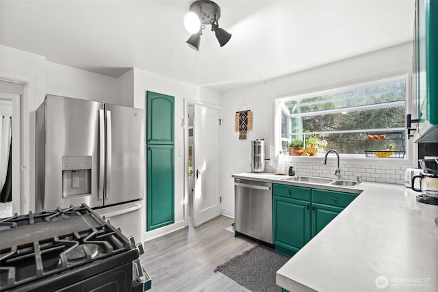 kitchen with stainless steel appliances, tasteful backsplash, light countertops, and green cabinetry