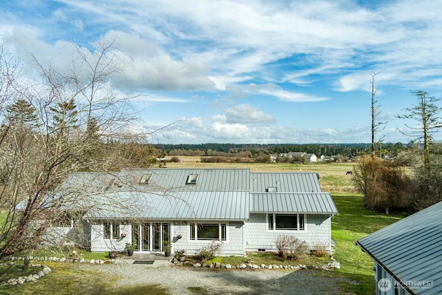 rear view of house with a lawn, crawl space, a standing seam roof, metal roof, and driveway