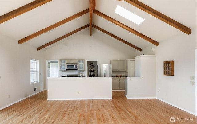 unfurnished living room featuring high vaulted ceiling, light wood-type flooring, a skylight, and beam ceiling