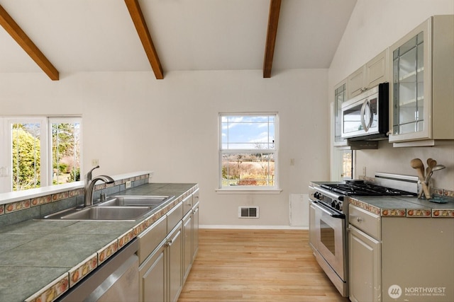 kitchen with stainless steel appliances, plenty of natural light, visible vents, and a sink