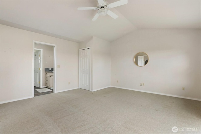 unfurnished room featuring lofted ceiling, carpet, baseboards, and a ceiling fan