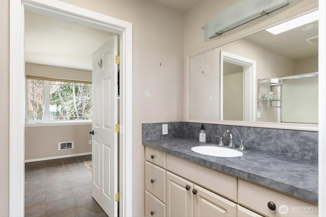 bathroom featuring baseboards, visible vents, vanity, and decorative backsplash