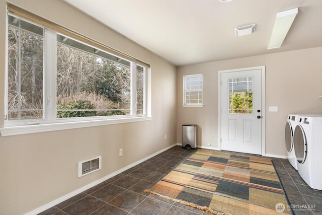 laundry area with laundry area, washing machine and clothes dryer, visible vents, and baseboards