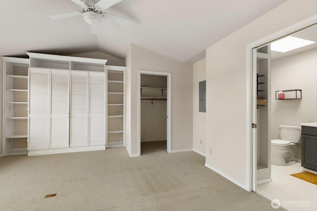 unfurnished bedroom featuring connected bathroom, light colored carpet, baseboards, vaulted ceiling, and electric panel