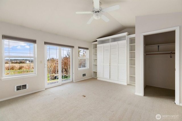 unfurnished bedroom featuring vaulted ceiling, carpet floors, visible vents, and access to exterior