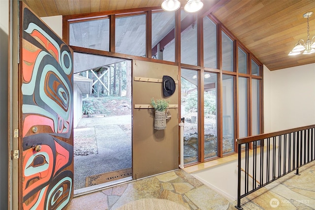 doorway to outside featuring wooden ceiling, stone tile floors, a chandelier, and vaulted ceiling