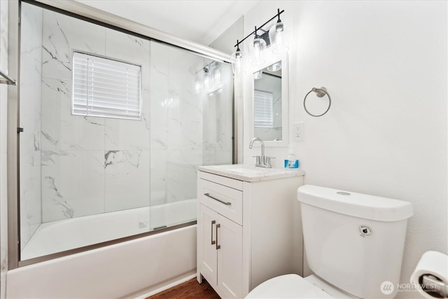 bathroom with toilet, bath / shower combo with glass door, and vanity