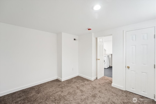 unfurnished bedroom featuring washer / dryer, carpet, visible vents, and baseboards