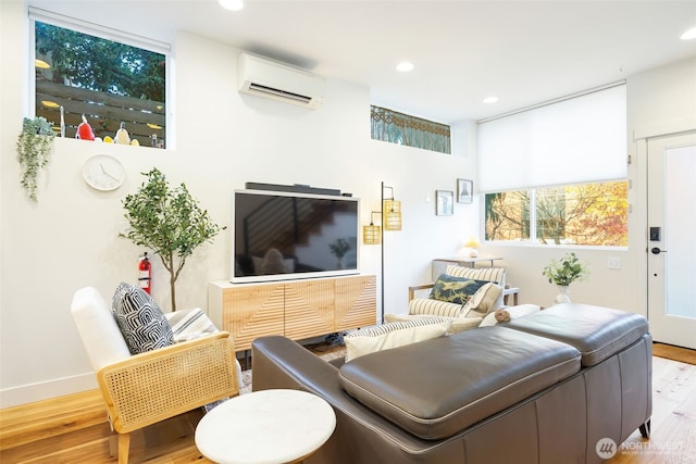 living room featuring a wall unit AC, wood finished floors, and recessed lighting