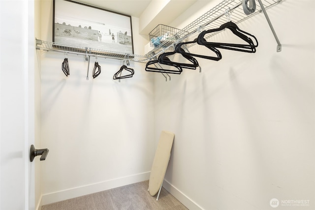 walk in closet featuring light colored carpet