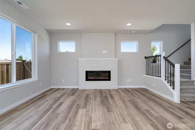 2401 SW Ridgeway Dr, Oak Harbor, WA 98277 - unfurnished living room with light wood-type flooring, a glass covered fireplace, stairs, baseboards, and recessed lighting
