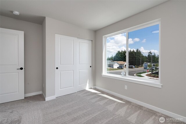 2401 SW Ridgeway Dr, Oak Harbor, WA 98277 - unfurnished bedroom with carpet flooring, baseboards, multiple windows, and a closet