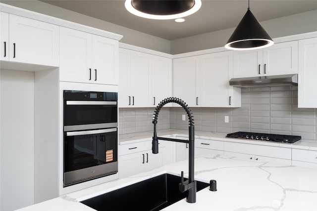 2401 SW Ridgeway Dr, Oak Harbor, WA 98277 - kitchen with under cabinet range hood, multiple ovens, a sink, black gas stovetop, and white cabinets