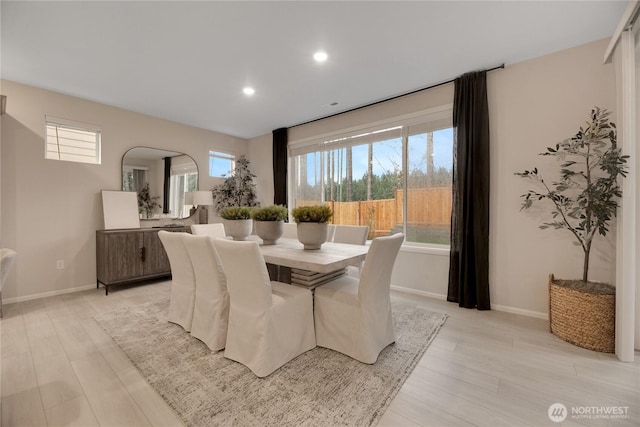 dining area with arched walkways, recessed lighting, baseboards, and light wood-style floors