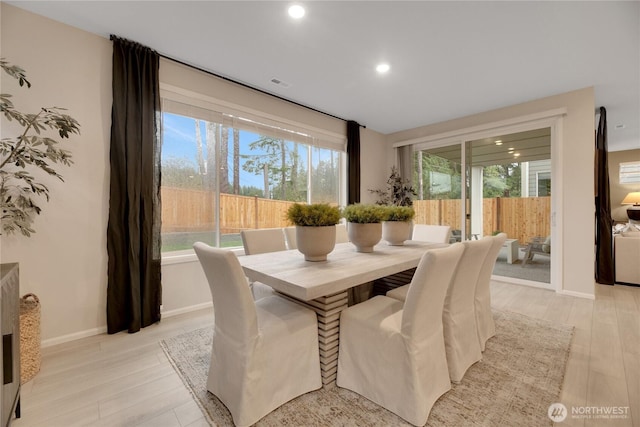 dining area with light wood-style floors, visible vents, and plenty of natural light