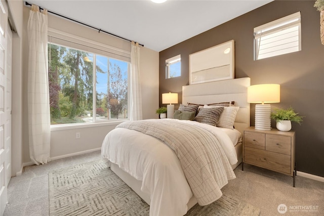 bedroom featuring light colored carpet and baseboards