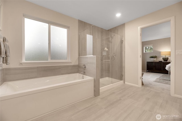 full bathroom featuring a stall shower, baseboards, and a bath