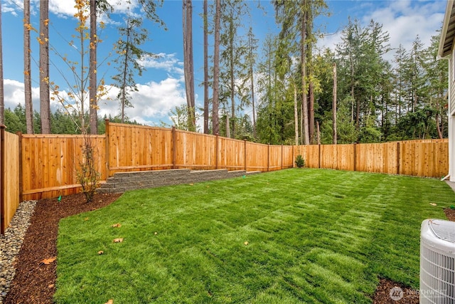 view of yard with central AC and a fenced backyard