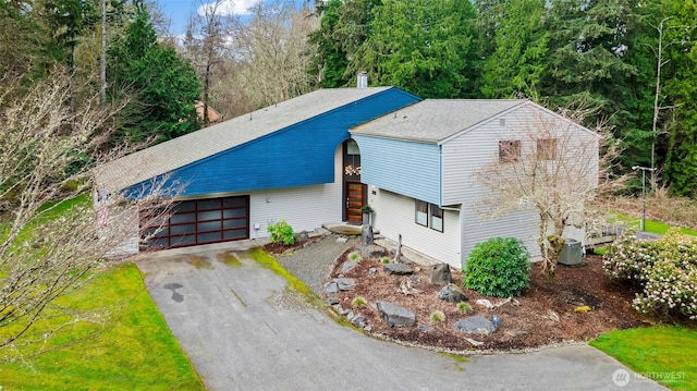 view of front of house with a shingled roof, driveway, and an attached garage