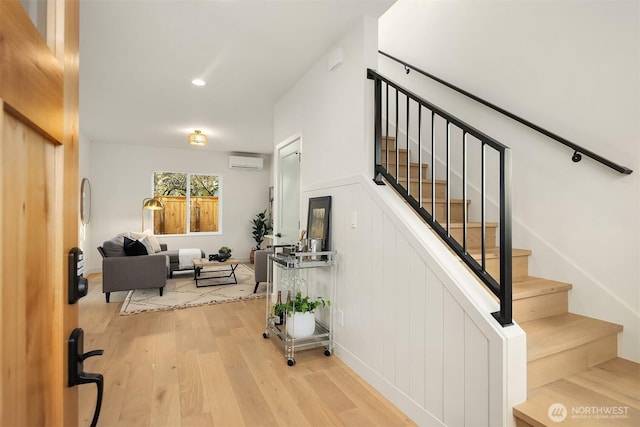 stairs with wood finished floors and a wall mounted AC