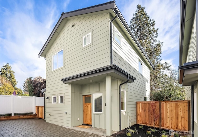 back of property featuring a patio area, fence, and board and batten siding