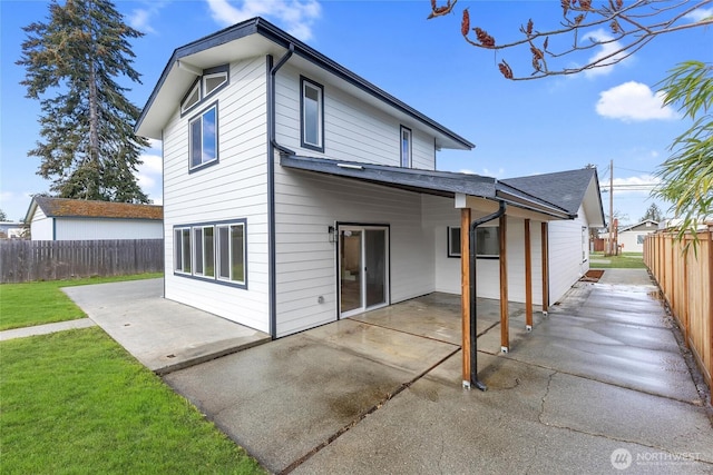 rear view of house featuring a lawn, a patio area, and fence