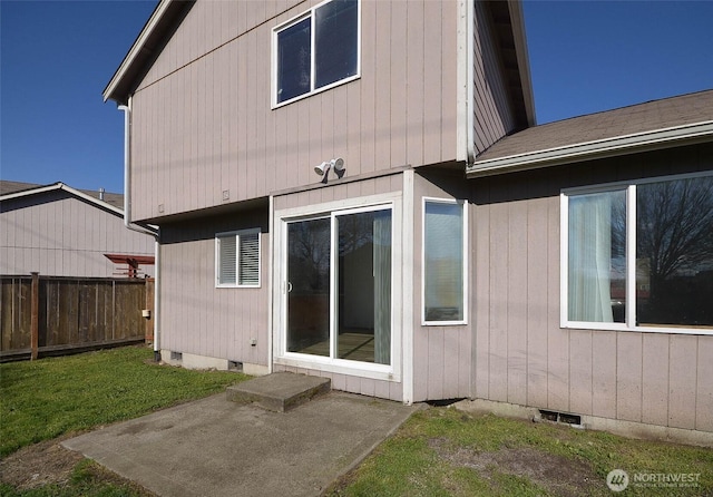 back of house with crawl space, fence, and a yard