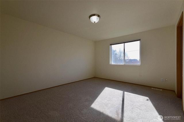 empty room with visible vents and carpet flooring