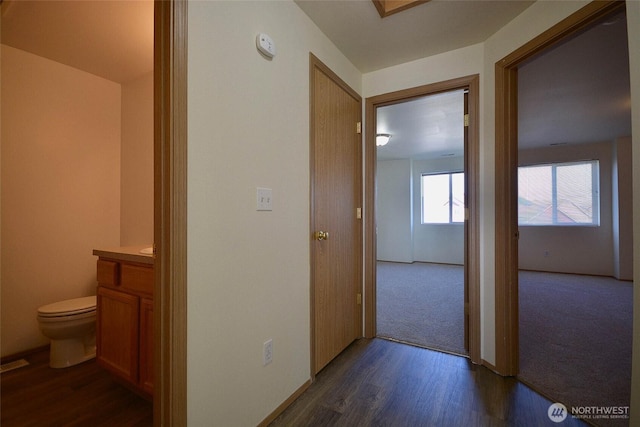 corridor with visible vents and dark wood-style flooring