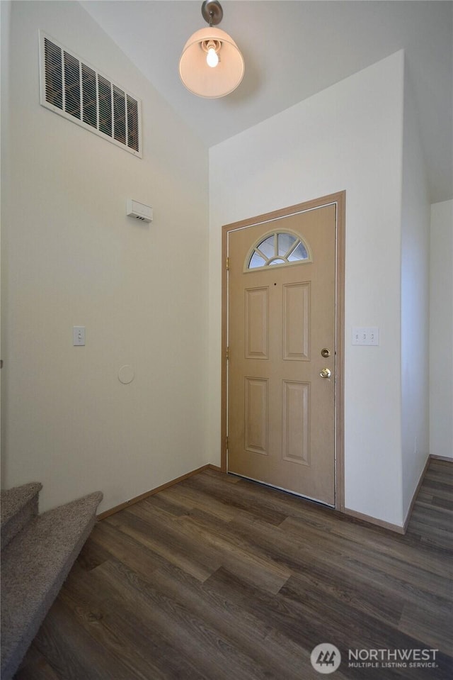 entrance foyer with dark wood-style flooring, visible vents, stairway, and baseboards