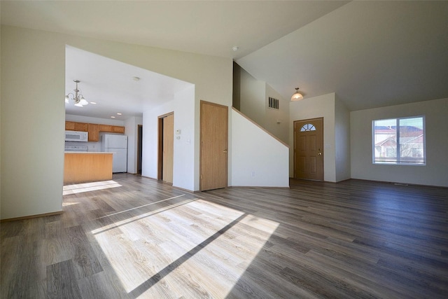 unfurnished living room featuring visible vents, high vaulted ceiling, a chandelier, and wood finished floors