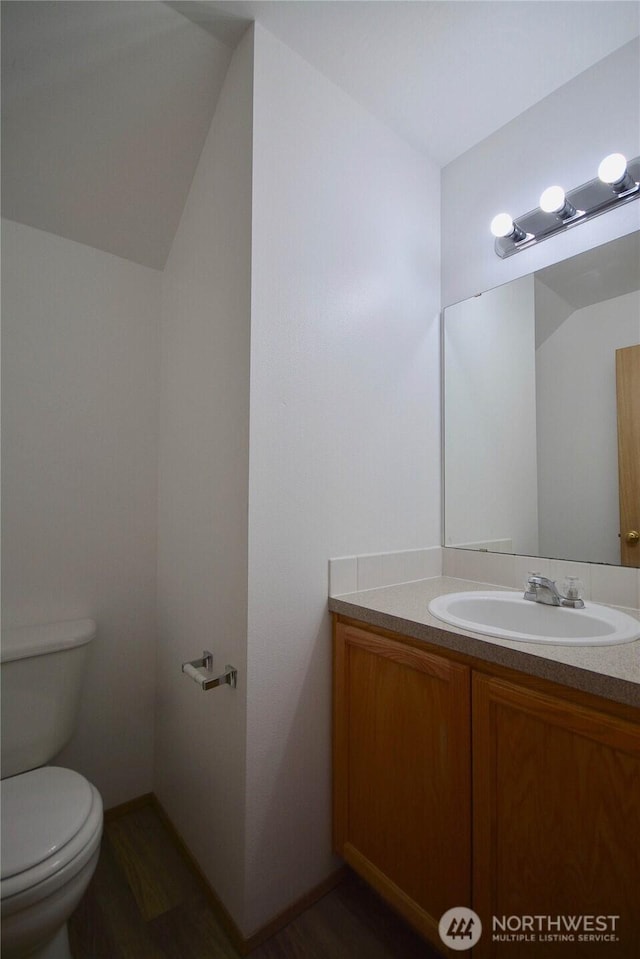 bathroom featuring toilet, wood finished floors, and vanity